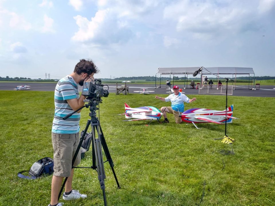 Dillon Carpenter filming an on-camera interview outdoors at a model aircraft event